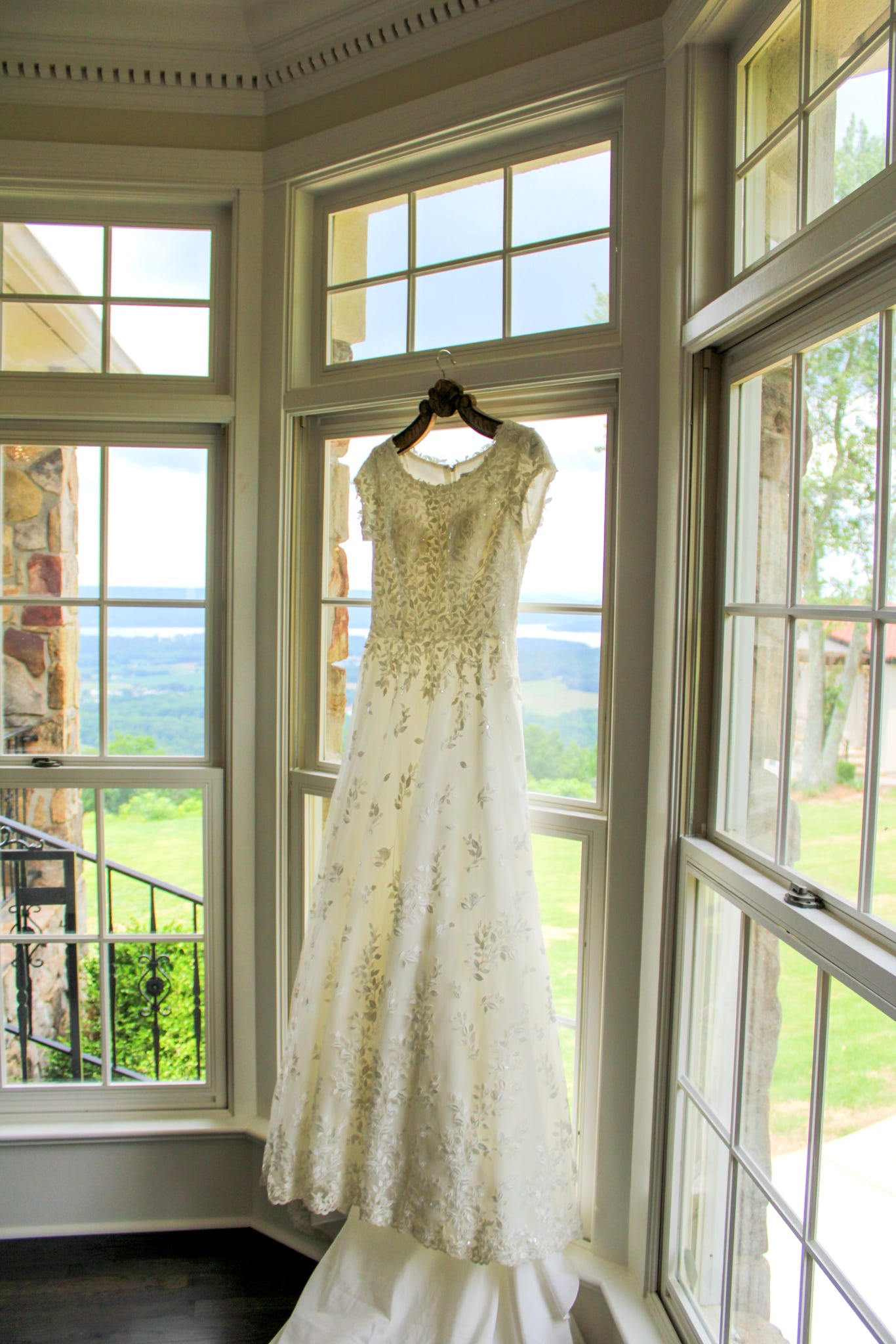 Bridal gown hanging in window with scenic view