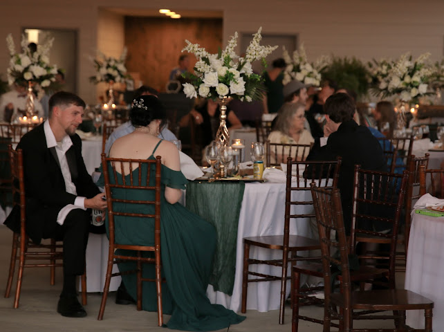 Elegant wedding reception guests at candlelit tables